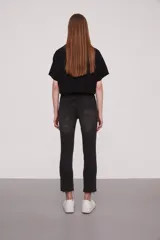 Pantalon jean de corte slim fit y tiro alto, con diseño de cinco bolsillos y ruedo deshilachado.