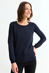 Sweater de punto fino en color gris con acabado metalizado, de corte recto, cuello redondo y manga larga.