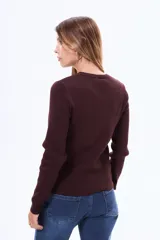 Buzo tejido de punto acanalado, color negro, con cuello redondo y mangas largas.