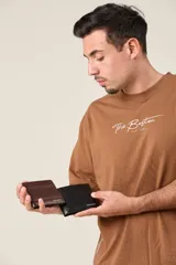 Billetera de ecocuero texturado color marrón con interior funcional y costuras reforzadas.