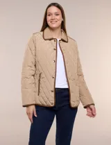 Campera matelaseada Michael Kors, de color beige con ribetes de ecocuero marrón. Cuenta con cuello con solapa, cierre frontal con broches metálicos, bolsillos laterales con cierre y mangas largas.