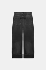 Jeans de tiro medio con corte baggy y pierna relajada. Presenta diseño de cinco bolsillos, cierre frontal con cremallera y botón, y bajo con vuelta marcada.
