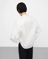 Camisa de algodón color blanco, con cuello camisero, manga larga con puño abotonado, cierre frontal con botones y un bolsillo aplicado en el pecho.