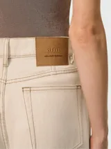 Pantalón de jean estilo wide leg en color beige, con tiro alto, cierre frontal con botón y bolsillos laterales.