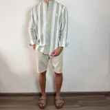 Camisa celeste y blanca a rayas verticales, de lino, con cuello mao y mangas largas con puños.