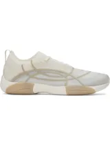 Championes de entrenamiento Under Armour modelo W Sculpt TR, color blanco con detalles en beige. Presentan una parte superior de micromalla transparente con diseño abstracto impreso en 3D, lengüeta de una sola pieza y entresuela de EVA con suela de goma.