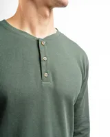 Remera tipo henley de manga larga confeccionada en tejido de algodón con textura mini piqué. Presenta un cierre frontal con tres botones y puños ajustados en las mangas.