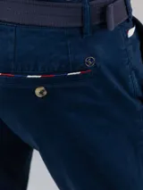 Pantalón chino de hombre color azul marino, de corte slim fit, confeccionado en gabardina de algodón, con bolsillos laterales y traseros, y cierre frontal de cremallera y botón.