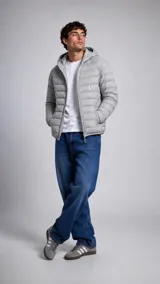 Campera puffer con capucha, color gris claro, con diseño acolchado horizontal y cierre frontal. Presenta un pequeño logo bordado en el pecho.