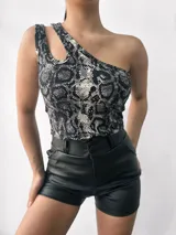 Top negro brillante de un solo hombro con abertura en el hombro izquierdo.