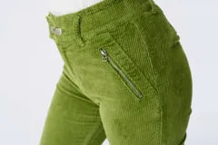 Pantalón de pana verde lima, tiro alto, corte skinny y pretina elastizada. Presenta bolsillos delanteros con cierre y dos botones en la cintura.