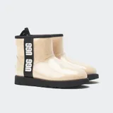 Botas cortas UGG Classic Clear Mini, impermeables, con exterior transparente y forro de borreguillo sintético color crema. Suela negra con relieve.