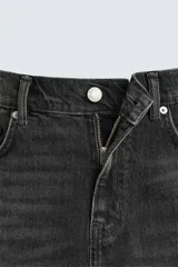 Bermuda de denim de algodón con elasticidad, color negro lavado. Modelo de tiro medio con corte regular fit, cinco bolsillos y cierre frontal con cremallera y botón.