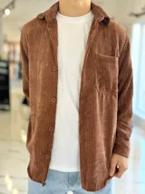 Sobrecamisa de pana color marrón chocolate, de manga larga, con cuello camisero, cierre frontal con botones y un bolsillo aplicado en el pecho.
