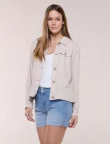 Camperita liviana de silueta recta y calce relajado de lino color beige, con cuello camisero, cartera frontal con botones símil madera y bolsillos aplicados con solapa en el pecho. Presenta mangas largas con puños de cierre abotonado y costuras reforzadas a tono.