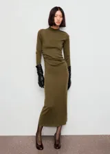 Vestido midi de punto fino color verde oliva, con cuello perkins, manga larga y diseño entallado con fruncidos laterales.