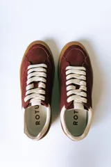 Championes urbanos de gamuza color bordó con suela de goma color caramelo y cordones blancos.