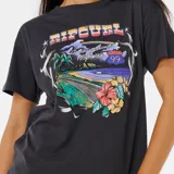 Remera negra de corte relajado con estampado de paisaje playero con palmeras, flores y la leyenda "Cruising down Highway 99" y el logo de Rip Curl.