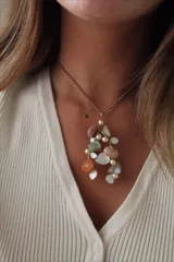 Collar con cadena dorada y colgante con piedras de colores y perlas.