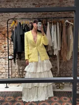 Blazer sastrero color amarillo pastel, de lino, con solapas de muesca, botones forrados y corte estructurado.