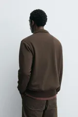 Sudadera regular fit de color marrón, con cuello alto y cierre frontal de cremallera corta, manga larga y puños y dobladillo en rib.