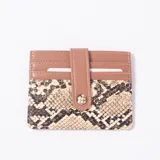 Tarjetero de cuero sint3tico en combinaci3n de color tustado con secci3n inferior con estampado animal print de serpiente, m3ltiples ranuras para tarjetas y tira con broche de presi3n.
