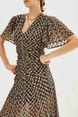 Vestido midi con estampado batik en tonos oscuros y dorados, de escote en V, mangas cortas con vuelo y detalle de fruncido central en la cintura.
