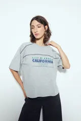 Remera negra de manga corta con estampado tipográfico "City of Angels California 1997" en tonos marrones y costuras visibles en blanco.