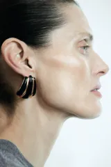 Pendientes de diseño geométrico con relieve, combinando piezas en color negro y dorado con acabado brillante.