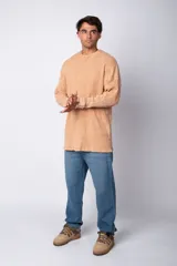 Buzo de corte oversize confeccionado en tela waffle de algodón con proceso de teñido acid wash. Presenta cuello redondo con detalle de costura en X y mangas largas con puños acanalados.