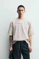 Sudadera de corte relajado confeccionada en tejido de algodón, con cuello redondo y manga corta. Presenta una aplicación de parche combinado a tono en la parte frontal y trasera.