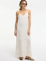 Vestido largo blanco con breteles finos, bordado con motivos florales en dorado. Espalda con abertura y cierre con botón.