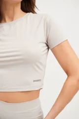 Remera corta de lycra color visón, de corte ajustado y mangas cortas.