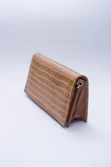 Cartera negra con textura símil cocodrilo y cadena metálica plateada.