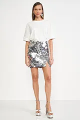 Remera blanca de corte holgado y mangas cortas con doblez.