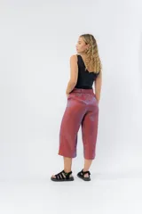 Pantalón de lino con acabado metalizado tornasolado, que refleja tonos entre rosa y lila según la luz. De corte recto y largo ¾, tiene cintura con elástico en la espalda que aporta comodidad y un calce relajado.