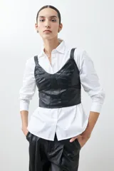 Top negro de cuero sintético con breteles finos y corte ajustado.