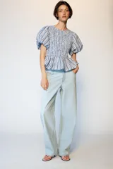 Top de cuello redondo con cuerpo de nido de abeja elástico y mangas globo con elástico en los puños. Presenta un diseño a rayas verticales en tonos azul, blanco y granate, con un bajo estilo peplum.
