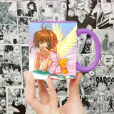 Taza blanca con asa violeta, estampada con una ilustración de Sakura Kinomoto, personaje del anime Sakura Card Captor.