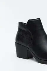 Bota corta de cuero sintético color marrón oscuro, con diseño minimalista, puntera afinada y taco ancho de altura media.