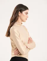 Polera dorada de cuello alto y manga larga, confeccionada en tejido elastizado con terminación metalizada.