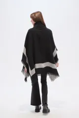 Poncho de tejido grueso, color negro y gris, con diseño de franjas diagonales y cuello alto con cierre. Presenta terminaciones con flecos.