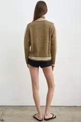 Campera tejida de algodón en color bordó y blanco, con cuello alto, cierre frontal completo y diseño con estampado tipográfico.