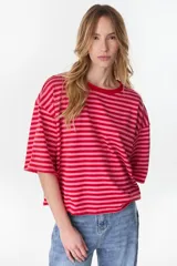Remera oversize de manga corta a rayas horizontales en tonos rojo y rosado, con cuello redondo.