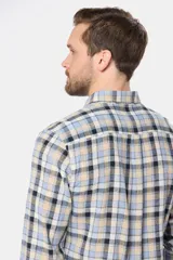 Camisa de lino de manga larga con diseño a cuadros en tonos celeste, beige, azul marino y blanco. Cuenta con cuello camisero, cierre frontal de botones y un bolsillo ojal en el pecho con logo bordado.