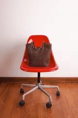 Bolso tipo tote bag de cuero trenzado a mano, en tonos marrón y negro, con asas trenzadas.