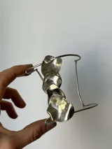 Brazalete plateado para el brazo, hecho a mano en alpaca, con diseño de formas orgánicas irregulares.