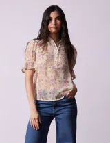 Blusa de gasa estampada marca Alex & Lili. Tiene cuello a la base con solapa y escote en V, mangas cortas con punto smock y terminación amplia. Delantera, solapa y mangas con aplique en crochet.