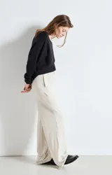 Sweater de punto de corte amplio y holgado, con cuello barco y mangas largas. Presenta una textura esponjosa y un diseño minimalista.