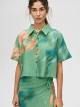 Falda midi tipo pareo color verde con estampado estilo tie-dye en tonos azul, naranja y blanco, con tiras ajustables en la cintura.